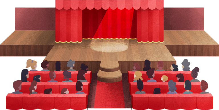 People seated in front of a stage with a spotlight shining in front of the red curtains